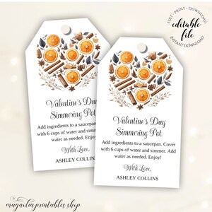 Può includere: Due etichette regalo stampabili con un design a forma di cuore che presenta fette d'arancia, bastoncini di cannella e altre spezie. Il testo sulle etichette recita "Valentine's Day Simmering Pot" e include istruzioni per preparare una pentola fumante. Le etichette sono state progettate da Ashley Collins.