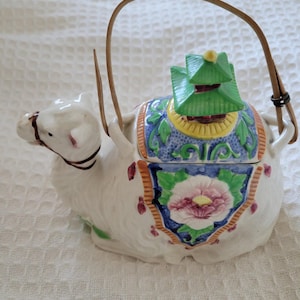 May include: A set of three ceramic mugs with a speckled, matte finish. The mugs are in shades of cream, light gray, and dark gray. Each mug has a simple, minimalist design and a rounded handle.