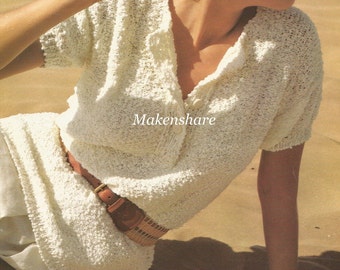 May include: A white knitted top with a v-neck and short sleeves. The top has a button closure and is worn with a brown belt.