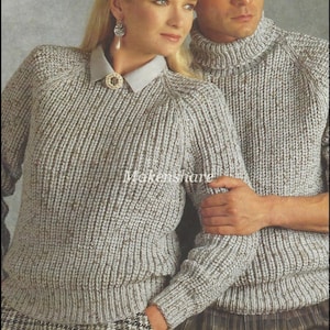 Op de afbeelding: Twee gebreide truien in een lichtgrijze kleur met een subtiele gevlekte textuur. De trui aan de linkerkant heeft een ronde hals en raglanmouwen. De trui aan de rechterkant heeft een hoge turtleneck en ingewerkte mouwen.