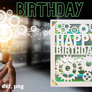 May include: A white card with a holographic finish features a cut-out design of gears and the text "Happy Birthday". The card is against a blurred background of a light bulb and gears.