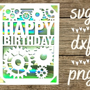 May include: A white card with a holographic background featuring the words "Happy Birthday" surrounded by gears. The card is on a wood background with the words "svg", "dxf", and "png" written in white.