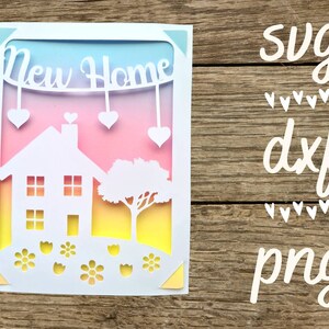 Pode incluir: Um cart&atilde;o branco com um design recortado de uma casa, uma &aacute;rvore e flores. O cart&atilde;o tem um fundo degrad&ecirc; arco-&iacute;ris e as palavras "New Home" est&atilde;o no topo.