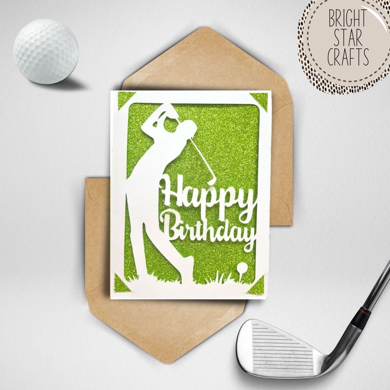 May include: A white card with a green glitter background and a white silhouette of a golfer swinging a club. The card says "Happy Birthday".