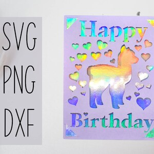 Puede incluir: Una tarjeta morada con una llama holográfica y corazones recortados. La tarjeta dice "Feliz cumpleaños" en una fuente arcoíris.