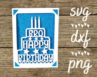 May include: White card with a blue glitter background and a white paper cut-out of a birthday cake with the words "BRO HAPPY BIRTHDAY" on it. The card is on a wooden surface.