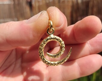 Op de afbeelding: Een gouden hanger in de vorm van een spiraal met een getextureerd oppervlak.