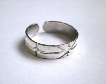 May include: A silver adjustable ring with a starburst design.
