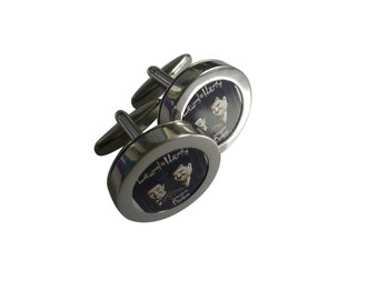 May include: A pair of silver cufflinks with a round, black and white image of Laurel and Hardy. The image is framed in a silver circle with the text "Laurel & Hardy" written around the edge.