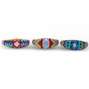 May include: Three silver rings with colorful inlaid designs. Each ring features a central opal stone surrounded by geometric patterns in shades of blue, green, red, and purple.