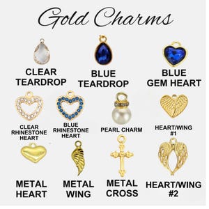 May include: A collection of gold charms labeled Gold Charms, including a clear teardrop, blue teardrop, blue gem heart, clear rhinestone heart, blue rhinestone heart, pearl charm, heart wing, metal heart, metal wing, metal cross, and heart wing.