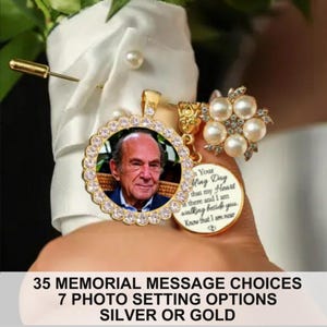 May include: A gold-toned memorial brooch featuring a circular pendant with a photograph of an older man, surrounded by a scalloped border of clear crystals. Attached is a smaller round charm with engraved text and a floral accent of white pearls.