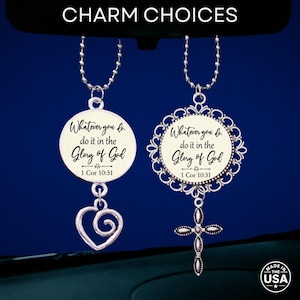 May include: Two silver-toned metal charms hanging from ball chains. The left charm is circular with a spiral heart pendant, while the right charm features an ornate filigree border and a cross pendant. Both display the text Whatever you do, do it in the Glory of God 1 Cor 10:31.