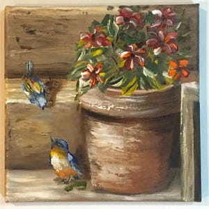 Op de afbeelding: Een schilderij van twee blauwe vogels die zitten in de buurt van een terracotta bloempot gevuld met rode en oranje bloemen.