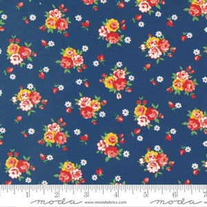 May include: A blue fabric with a repeating pattern of red, yellow, and white floral bouquets. The fabric has a white ruler with black markings and the text "moda" printed on it.