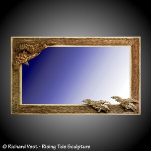 May include: A rectangular mirror with a textured brown wooden frame. The frame features three sculpted sea turtles attached to the edges, with one turtle in the upper left corner and two smaller turtles positioned along the bottom right edge.