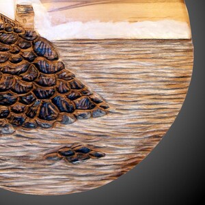 A round wall carving depicting an East coast lighthouse.  White staining on the lighthouse and waves and also for the fog.  hanger on back, ready for wall  hanging.  signed/copyrighted, for indoor display only. Carved in red gum wood.
