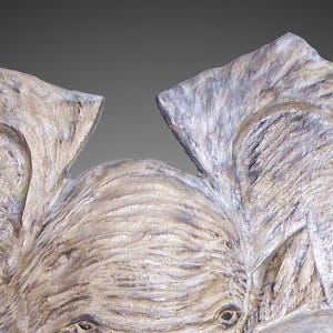 Puede incluir: Primer plano de una cabeza de elefante de madera tallada con textura detallada y un color marr&oacute;n claro.