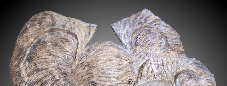 Puede incluir: Primer plano de una cabeza de elefante de madera tallada con textura detallada y un color marr&oacute;n claro.