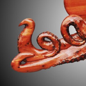 the crawling Octopus in Tennessee Red Cedar wood, tung oil finish.  the artist carves suction cups on each tentacle,  hangers on reverse, for indoor display only. Darkened torched suction cups.  signed/copyrighted. a must for octopus collector.