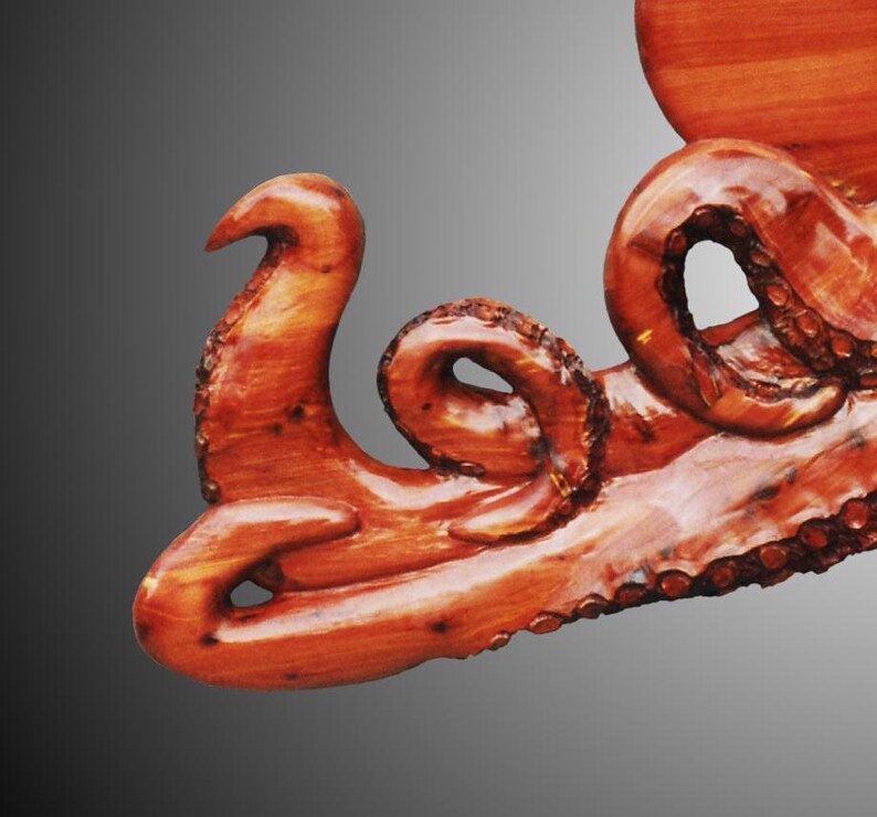 the crawling Octopus in Tennessee Red Cedar wood, tung oil finish.  the artist carves suction cups on each tentacle,  hangers on reverse, for indoor display only. Darkened torched suction cups.  signed/copyrighted. a must for octopus collector.
