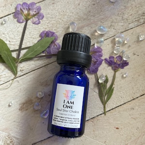 Può includere: Una bottiglia di vetro blu con un tappo nero e un'etichetta bianca che recita "I AM ONE Soul Star Chakra Essential Oil Blend A divine blend of Peony Absolute, Lemon, Tangerine, Lotus, and Oak Moss essential oils in sweet almond SACRED WILD DIVINE"