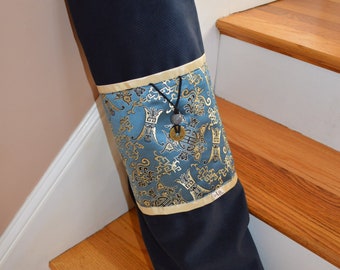 May include: A blue and gold yoga mat bag with a drawstring closure and a decorative tassel. The bag is made of a soft, durable fabric and has a traditional Chinese design.