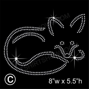 May include: A rhinestone cat design on a black background. The cat is made of small, sparkling rhinestones. The design is 8 inches wide and 5.5 inches high. A white circle with the letter "C" is in the lower left corner.