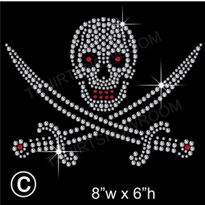 May include: A rhinestone skull and crossbones design with red accents. The design is 8 inches wide and 6 inches tall.