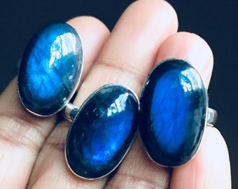 May include: Three silver rings with oval-shaped blue labradorite gemstones. The rings are set in silver and have a polished finish.