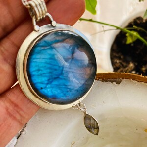 "Celebrate love with Earthkarmajewellery's Nautical Blue Labradorite Pendant, adorned with the beauty of a round blue moon, intricately set in sterling silver, and radiating distinctive elegance, featuring a moonstone dangle."