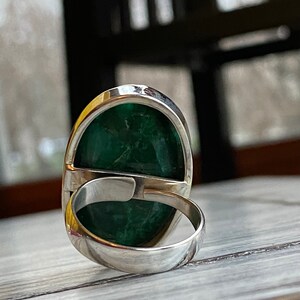 Adjustable band silver ring with a large gemstone statement for women . The ring is shown from the side, with the band facing the viewer.