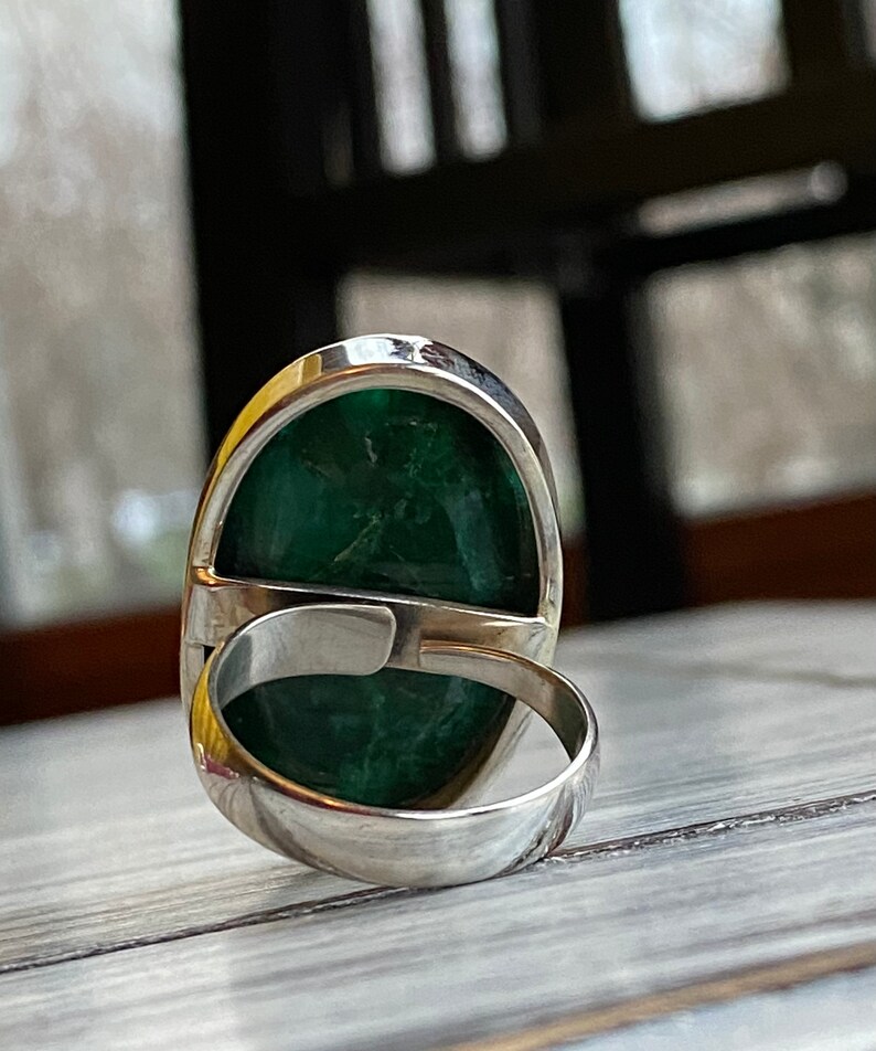 Adjustable band silver ring with a large gemstone statement for women . The ring is shown from the side, with the band facing the viewer.