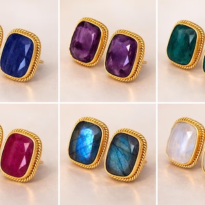 May include: Six pairs of gemstone stud earrings. Each pair features a different colored rectangular gemstone set in a gold-colored, rope-textured frame. The gemstones are blue, purple, green, red, blue-green, and white.