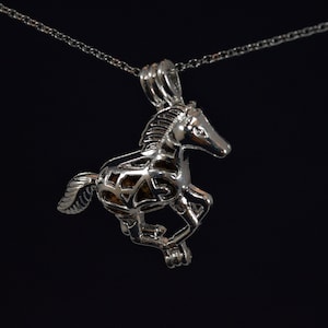 May include: A silver horse charm necklace with a delicate chain. The horse is in a running pose and has a detailed design.