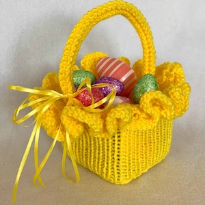 May include: A yellow crocheted Easter basket with a ruffled edge and a yellow ribbon. The basket is filled with colourful Easter eggs.