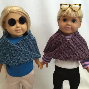 Puede incluir: Dos mu&ntilde;ecas con bufandas de punto. La mu&ntilde;eca de la izquierda lleva una bufanda azul y gafas redondas. La mu&ntilde;eca de la derecha lleva una bufanda morada y gafas de montura amarilla.