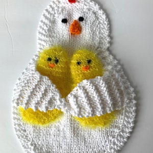 May include: White knitted chicken dishcloth with two yellow chicks inside. The chicken has a red comb and black eyes.