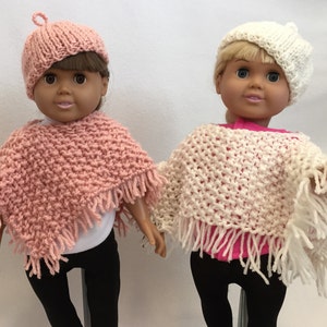 Puede incluir: Dos mu&ntilde;ecas con ponchos y gorros tejidos. La mu&ntilde;eca de la izquierda lleva un poncho y un gorro rosa, mientras que la mu&ntilde;eca de la derecha lleva un poncho y un gorro blanco.