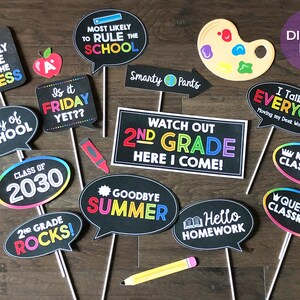 May include: A set of 12 printable photo booth props for a second grade classroom party. The props feature colorful text and graphics on a black chalkboard background. Some of the props include "I'm only here for the recess", "Is it Friday yet?", "Watch out 2nd grade here I come!" and "Goodbye Summer".