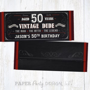May include: A black and red chocolate bar wrapper with a chalkboard design. The wrapper says "Premium Aged 50 Years Vintage Dude Edition" and "The Man The Myth The Legend". It also says "Jason's 50th Birthday".