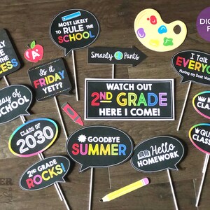 May include: A set of 12 printable photo booth props for a second grade graduation party. The props feature colorful speech bubbles with phrases like "Watch Out 2nd Grade Here I Come!" and "2nd Grade Rocks!"