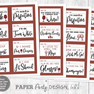 May include: A set of 12 red wine-themed sticker labels with funny sayings. The labels feature a wine glass icon and text such as "I'm aged to perfection", "I'm on team red", "I'm the group therapist", "I make pour decisions", "I stop to smell the rose", "I'm fit shaced", "I need glasses", "Let the good times flow", "Wine me up and watch me go", "Sta la vino baby", "I came for the champagne", and "Drinks well with others".