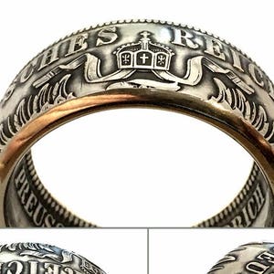 May include: A silver ring made from a German 5 Mark coin. The ring features the inscription "Deutsches Reich" and a coat of arms with a crown.