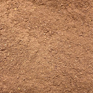 May include: Close-up of a pile of ground coffee beans. The coffee is a dark brown color and has a fine texture.