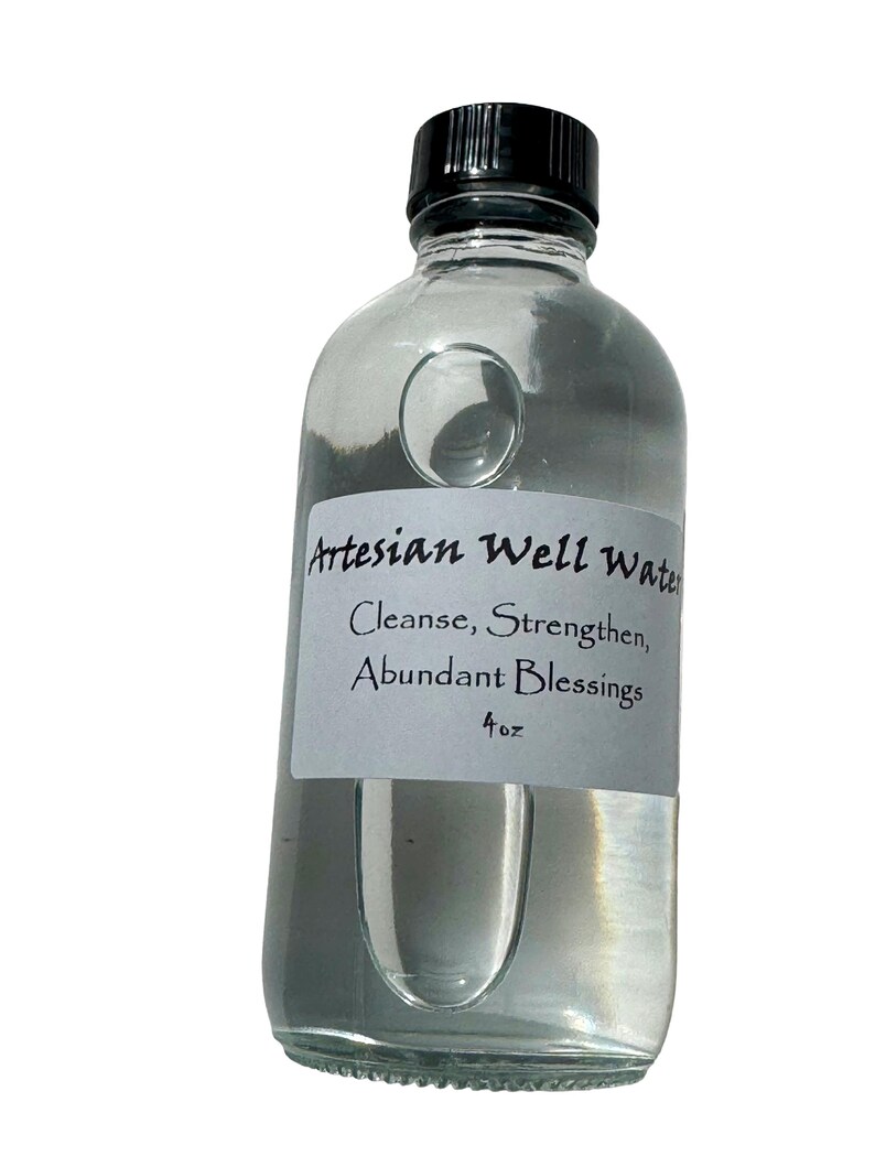 May include: A clear glass bottle filled with liquid, featuring a black cap and a white label. The label reads "Artesian Well Water" with the phrases "Cleanse, Strengthen, Abundant Blessings" and "4 oz."