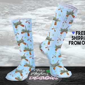 May include: A pair of blue socks with a white background and a repeated pattern of brown paddles and green leaves. The text "Slot Creek Survivor" is repeated on the socks.