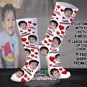 May include: White socks with a repeated pattern of red hearts and a child's face. The text "I Love You Daddy!" is printed on the socks. The socks are customizable with a picture and message.