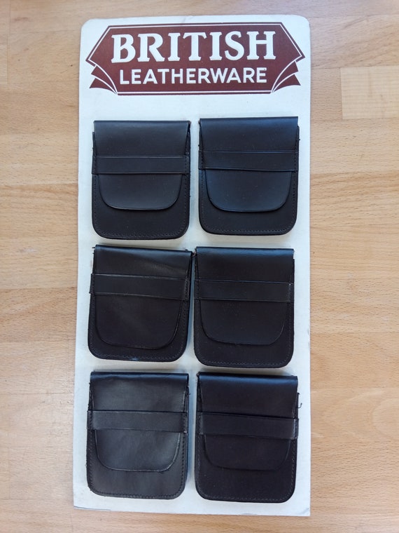 Card of six brown British Leatherware wallets