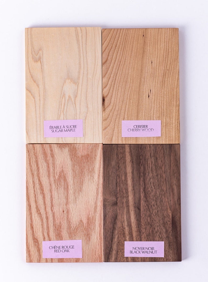 May include: Four wood samples, each with a different grain pattern and color. The samples are labeled with their names in French and English: &Eacute;rable &agrave; Sucre / Sugar Maple, Cerisier / Cherry Wood, Ch&ecirc;ne Rouge / Red Oak, Noyer Noir / Black Walnut.